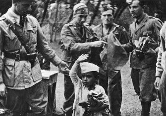 A young Ethiopian performs the fascist salute for some Italian soldiers, c. 1936-37. Narodowe Archiwum Cyfrowe. Public Domain.