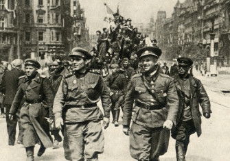 Two Red Army officers march onto Prague’s Wenceslas Square ahead of their tanks, 1945. Moravian Library in Brno. Public Domain.