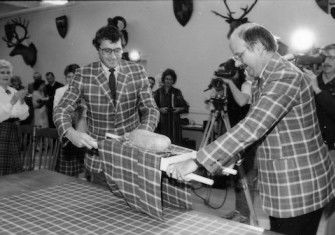 A haggis in is placed on a table adorned with Vancouver centennial tartan, Glen E. Erickson, 22 January 1986. City of Vancouver Archives (CC BY 2.0).