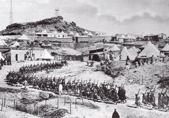 A column of French troops on the move in a tented encampment in Morocco.
