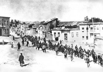 Armenian civilians, escorted by armed Ottoman soldiers, are marched through Harput (Kharpert), April 1915.