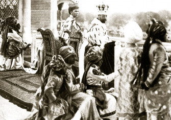 George V and Queen Mary watching the Delhi Durbar from the Red  Fort, accompanied by Indian princes acting as pages, 1911.