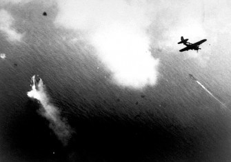  U.S. aircraft, such as this Curtiss SB2C-3 Helldiver, begin their attacks on Yamato (center left). A Japanese destroyer is in the center right of the picture.