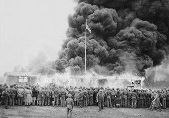 A crowd watches the destruction of the last camp hut.