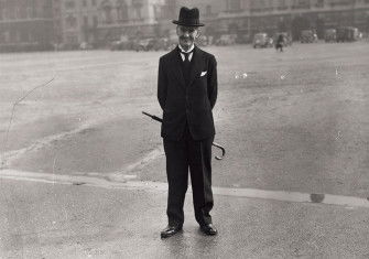 Neville Chamberlain stands, with his umbrella, on Horse Guards Parade, off Whitehall, London, 18 March 1940. 