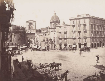 View of a square with the Porta Capuana in the background and the dome of the Santa Caterina a Formiello in Naples, Italy