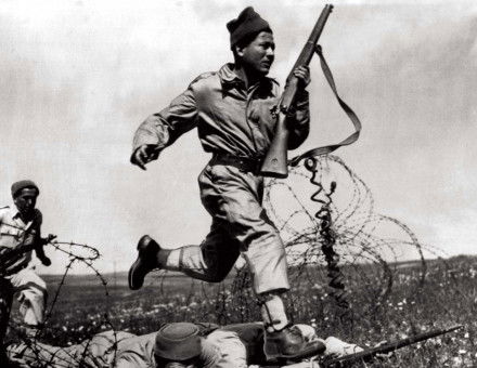 a Haganah fighter dashes across a human bridge formed by two comrades over barbed wire, Tel Aviv, 1948. 