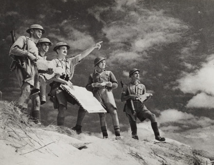 British soldiers in the desert studying maps and terrain.