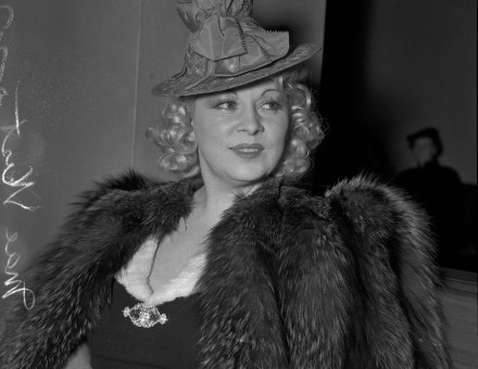 Mae West in court during questioning about earnings from her role in the movie "She Done Him Wrong," Los Angeles, 1940. University of California, Los Angeles. Library. Department of Special Collections (CC BY 4.0 DEED).