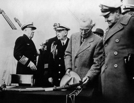 resident Harry S. Truman reviews a Japanese sword on the USS Missouri (BB-63) surrender table, 1945. Naval History and Heritage Command. Public Domain.