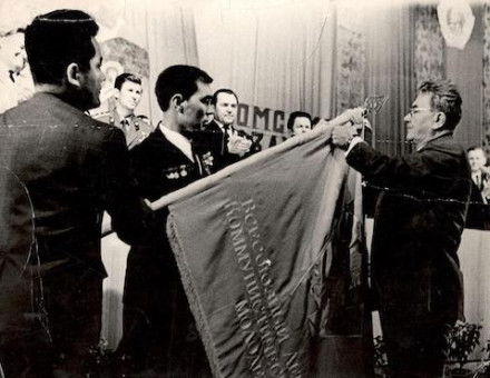 Dinmukhamed Kunaev, First Secretary of the Communist Party of Kazakhstan, awarding a Soviet Army unit's battle flag, 1986. EgemenMedia (CC BY-SA 4.0).