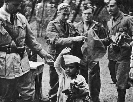 A young Ethiopian performs the fascist salute for some Italian soldiers, c. 1936-37. Narodowe Archiwum Cyfrowe. Public Domain.