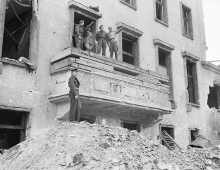 British_and_Russian_soldiers_on_the_balcony_of_the_ruined_Chancellery_in_Berlin,_5_July_1945._BU8635.jpg