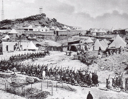 A column of French troops on the move in a tented encampment in Morocco.