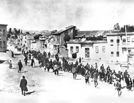 Armenian civilians, escorted by armed Ottoman soldiers, are marched through Harput (Kharpert), April 1915.