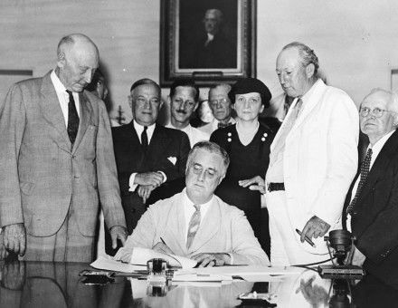 Roosevelt signs the Social Security Act, August 14, 1935